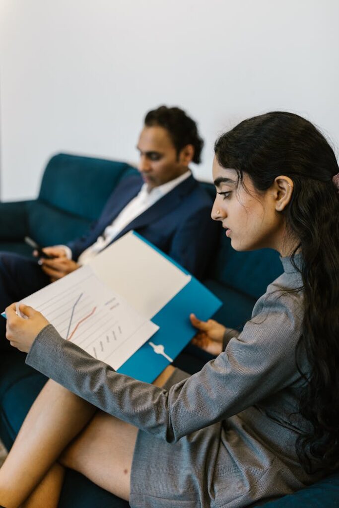 Two professionals reviewing data charts in a modern office setting.